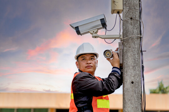 A CCTV installer is installing a security camera. security concept.