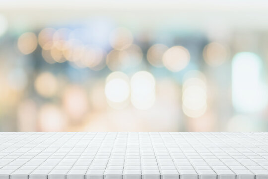 Empty white ceramic mosaic table top and blurred bokeh cafe and restaurant background with vintage filter - can used for display or montage your products.