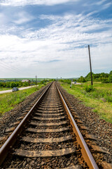 Summer landscape with railroad rails and road