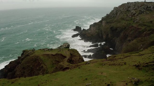 Aerial pan along the rough coastline of Cornwall, England, revealing ruins of the tin mines, part of the dramatic scenery used in the Masterpiece Theater presentation of Poldark.