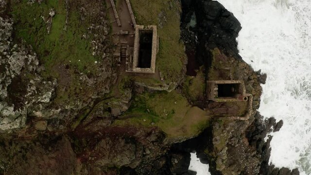 Aerial overhead of the abandoned tin mine buildings perched on the edge of the British Isle.