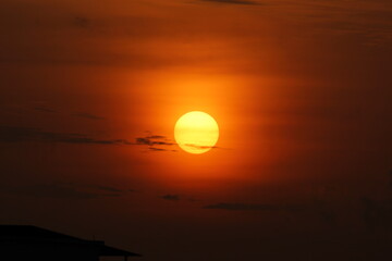 Fototapeta premium Early morning yellow color sun with orange sky and black clouds