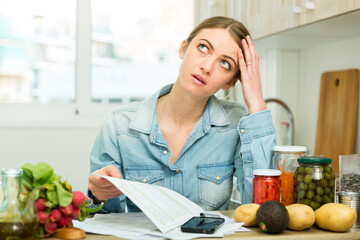 Woman counting money for paying bills at kitchen. High quality photo