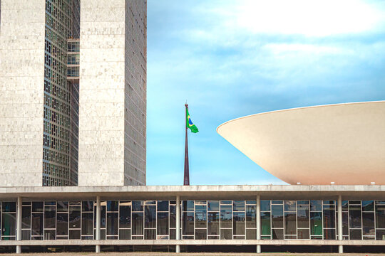 Bandeira do Brasil atr&aacute;s do Congresso Nacional do Brasil. Pr&eacute;dio do parlamento brasileiro - C&acirc;mara dos Deputados e Senado Federal. Bras&iacute;lia, Distrito Federal - Brasil. 06 de Junho de 2021.