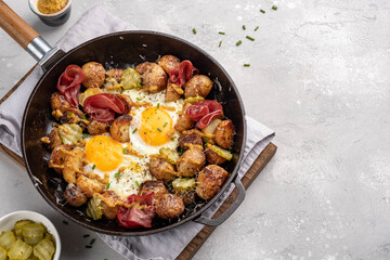 Potato hash with fried eggs and meat pastrami for breakfast branch