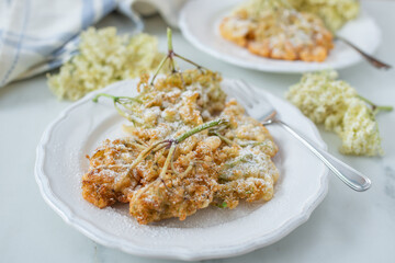 Sweet home made fried elderflowers in pancake on a table