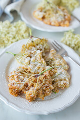 Sweet home made fried elderflowers in pancake on a table