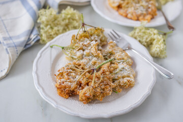 Sweet home made fried elderflowers in pancake on a table