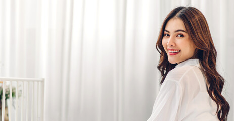 Portrait of smiling cheerful beautiful pretty asian woman clean fresh healthy white skin posing in pajamas white clothes.Girl felling relaxing and enjoy time on the bed at home.asia beauty