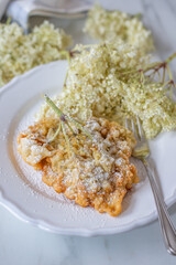 Sweet home made fried elderflowers in pancake on a table