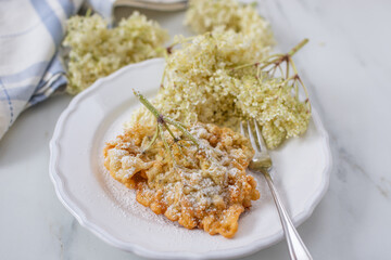 Sweet home made fried elderflowers in pancake on a table