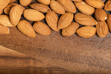 Almonds isolated on wooden background. Top view. Macro photography