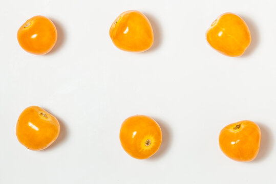 Pattern texture of several Cape Gooseberries, or goldenberries. White background. Top view.
