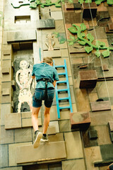 teen boy on indoor climbing wall, bourdering