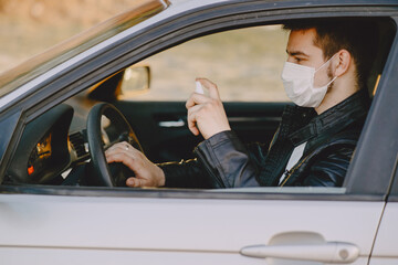 Man in a mask disinfect the car