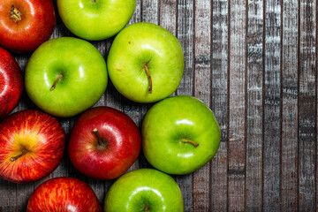 Fresh red and green apples on wooden background. Top view.