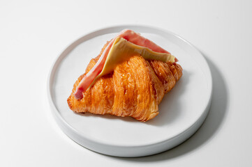 Ham and Cheese croissant sandwich on white plate food concept.
