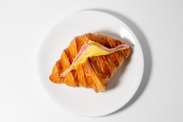 Ham and Cheese croissant sandwich on white plate food concept.