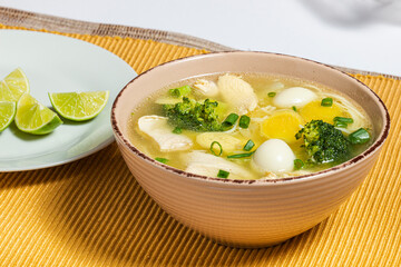 Chicken ginseng soup with broccoli, quail eggs and lemon. Traditional food.