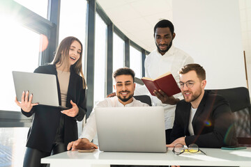 Group of multiracial business people working at laptops in company office