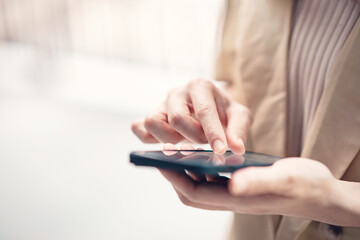 Closeup female using smartphone, she chatting online messaging and social network on mobile.