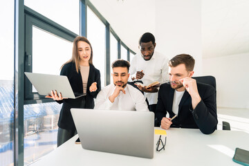 Office workers working together on laptop