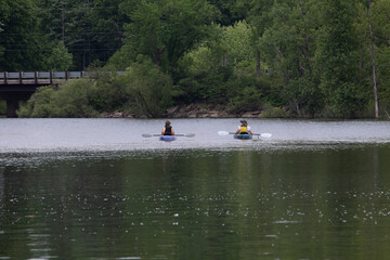 mature kayakers paddle on lake water for relaxing recreation