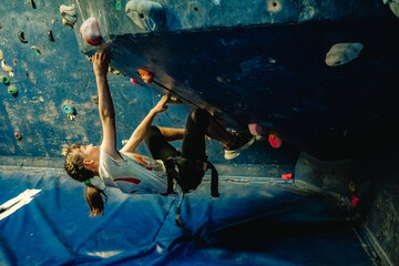 young child girl on climbing wall, bouldering