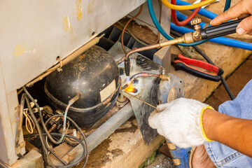 repair old refrigerator job,technician wear gloves welding copper pipe by gas before vacuum system...
