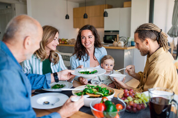Fototapeta na wymiar Happy multigeneration family indoors at home eating healthy lunch.