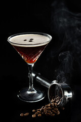 Alcohol cocktail Espresso Martini cocktails garnished with coffee beans, beans in espresso holder in smoke and on black background. Copy Space.