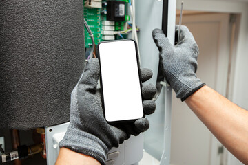The electrician showing the phone with blank screen. Mockup for house repair or building