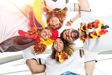 Gruppe glücklicher Fußballfans aus Deutschland feiern gemeinsam einen Meisterschaft Sieg.