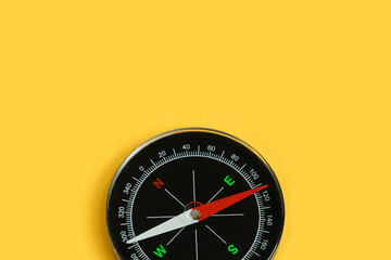 Top view single black compass isolated on yellow background