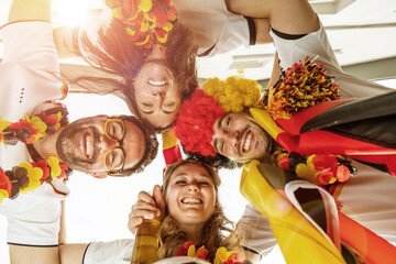 Gruppe glücklicher Fußballfans aus Deutschland feiern gemeinsam einen Meisterschaft Sieg.