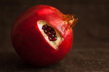 Juicy garnet, ripe pomegranate fruit on wooden background.