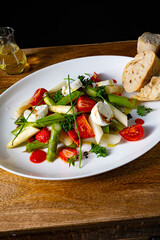 Asparagus salad with strawberries, tomatoes and goat cheese