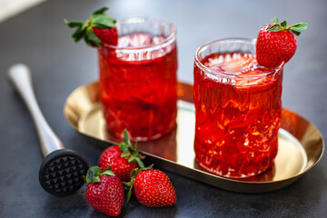 Red drink with ice and strawberry with leaves