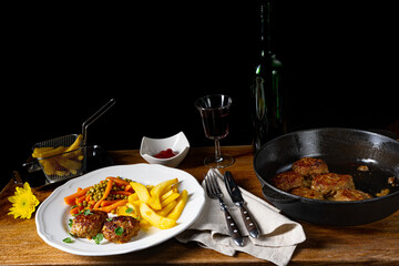 Homemade meatballs with french fries and vegetables