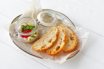 Pieces of bread with fish pate on white wooden table