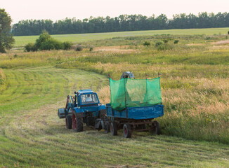 Fototapeta premium harvesting grass by machine on the field for planting