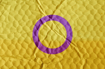 Intersex pride flag on an uneven textured surface.