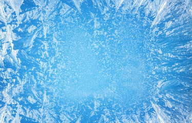 Frosty patterns on the edge of a frozen window. - obrazy, fototapety, plakaty