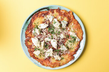 Healthy home-made vegetarian potato pizza. Delicious cheese and fresh greenery on a potato pancake.