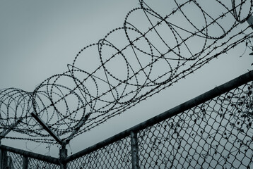 Prison security fence. Barbed wire security fence. Razor wire jail fence. Barrier border. Boundary...