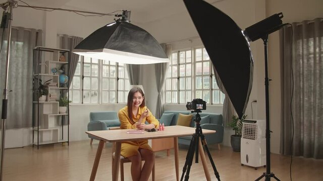 Beauty Blogger Woman Filming Daily Make-Up Routine Tutorial On Camera. In fluencer Girl Live Streaming Cosmetics Product Review In Home Studio With Professional Lighting Equipment. Vlogger Job
