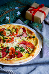 Cooked pizza on aged blue wooden surface background with copy space, side view.