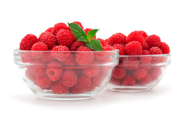 Raspberries and mint leaves in a glass bowls.
