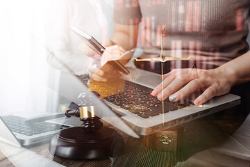Justice and law concept.Male judge in a courtroom with the gavel, working with, computer and docking keyboard, eyeglasses, on table in morning light