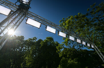 A lot of LED lights prepared for an event. Professional filming gear and equipment against blue sky background.